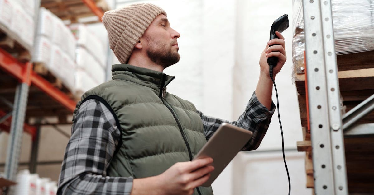 Warehouse worker scanning inventory bins with a barcode scanner during a cycle count