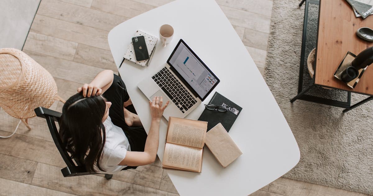 Ecommerce operator reviewing AI-generated reports on a laptop with a four-hour daily schedule pinned to the wall